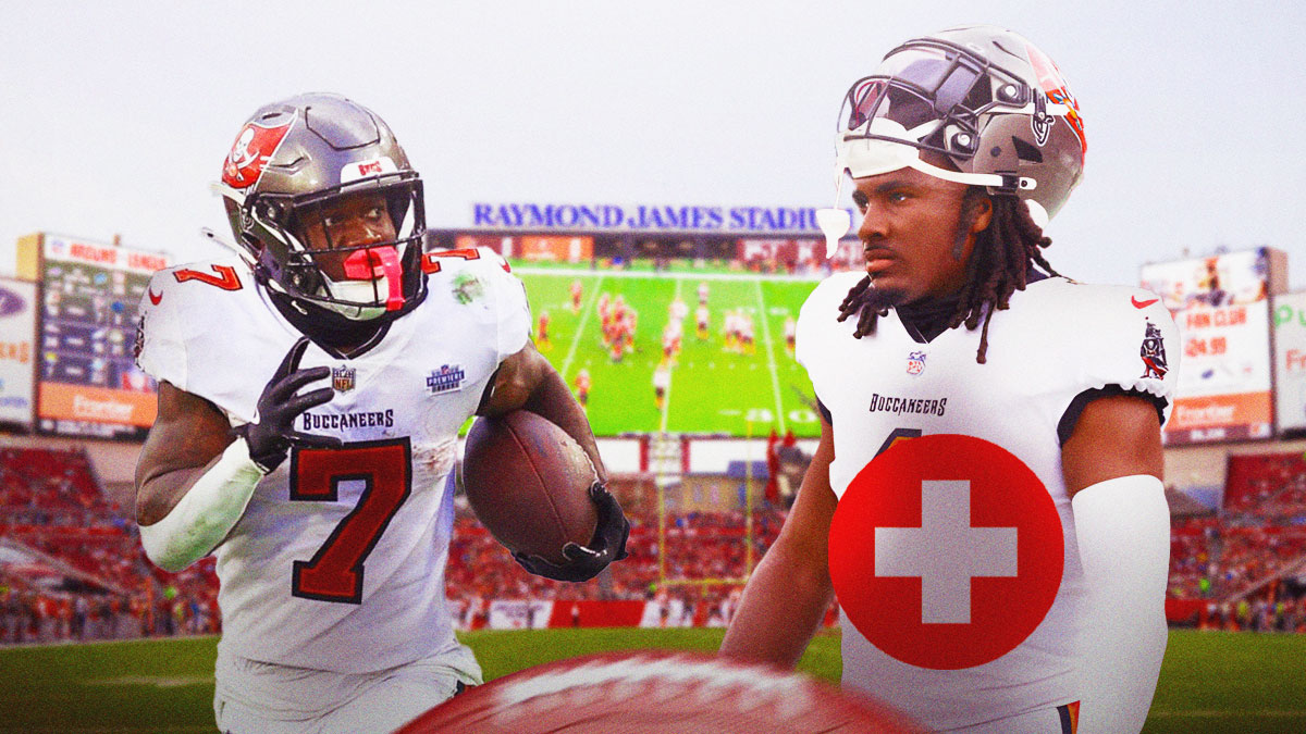 Rachaad White with a medical cross over his jersey next to Bucky Irving in front of the Buccaneers stadium.