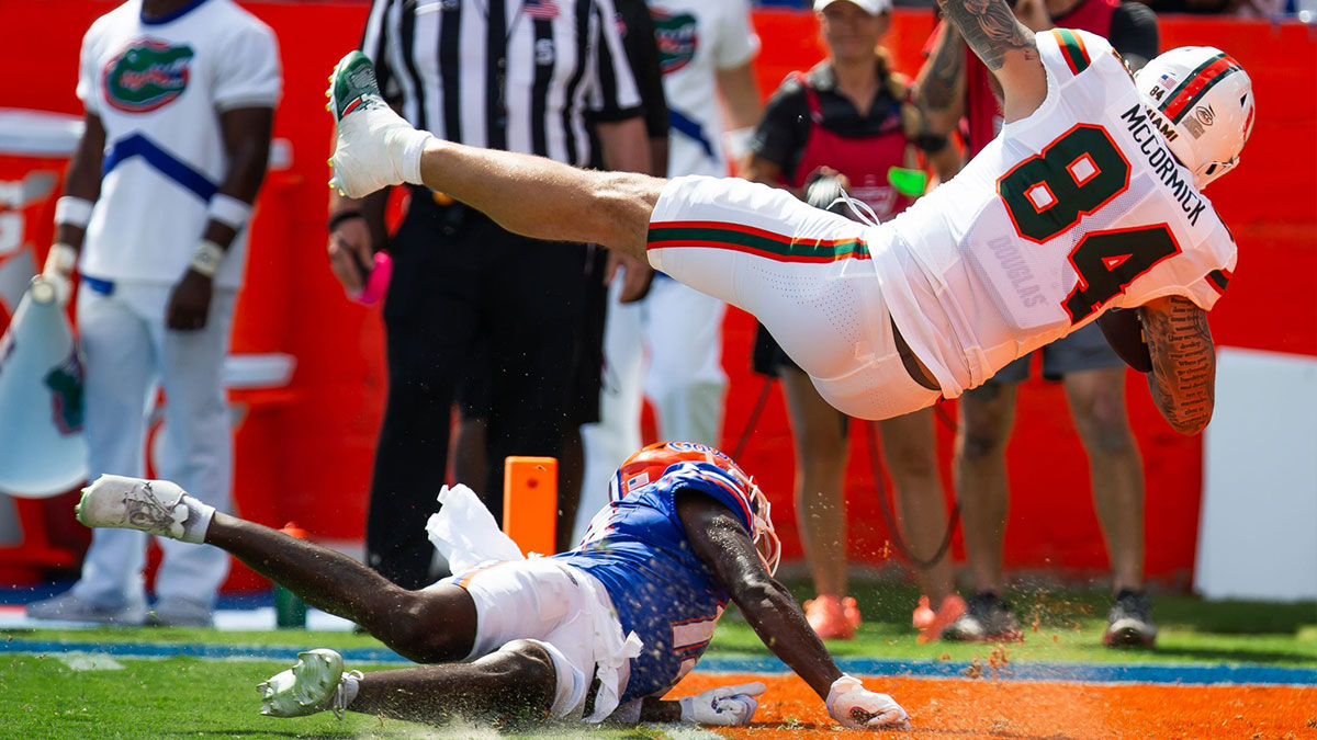 Florida Gators defensive back Jordan Castell (14) upends Miami Hurricanes tight end Cam McCormick (84) as he scores a touchdown during the season opener at Ben Hill Griffin Stadium
