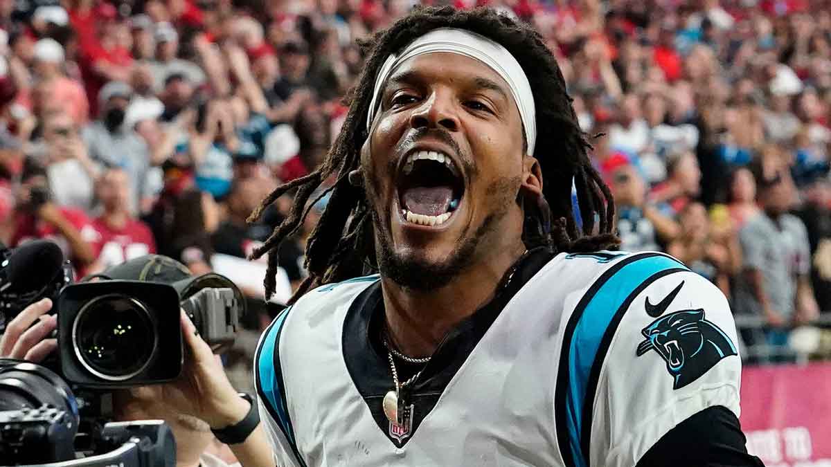 Carolina Panthers quarterback Cam Newton yells \"I'm back!\" after scoring a rushing touchdown against the Arizona Cardinals in a game