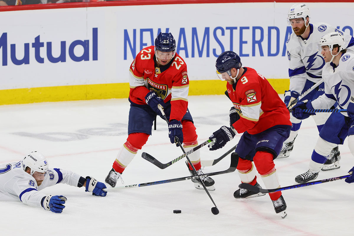 Florida Panthers center Carter Verhaeghe (23) and Florida Panthers center Sam Bennett (9) battle for the puck against Tampa Bay Lightning defenseman Erik Cernak (81) during the third period in game one of the first round of the 2024 Stanley Cup Playoffs at Amerant Bank Arena.
