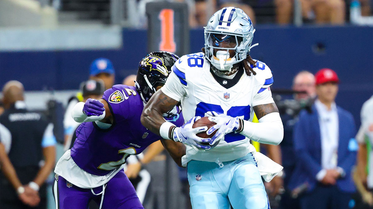 Dallas Cowboys wide receiver CeeDee Lamb (88) runs with the ball as Baltimore Ravens cornerback Nate Wiggins (2) defends during the first half at AT&T Stadium.