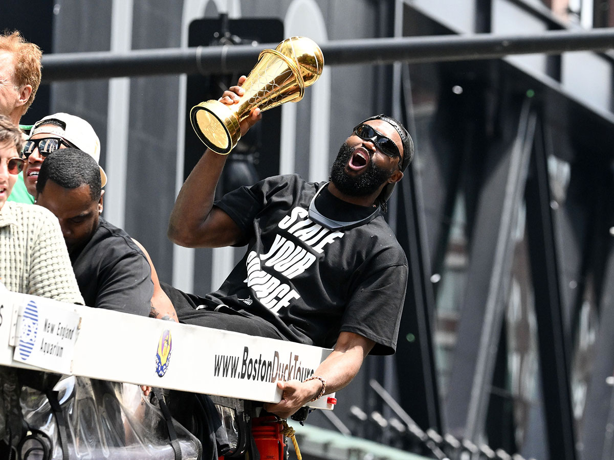 Celtics guard Jaylen Brown (7) holds the MVP trophy during the 2024 NBA Championship parade in Boston. 