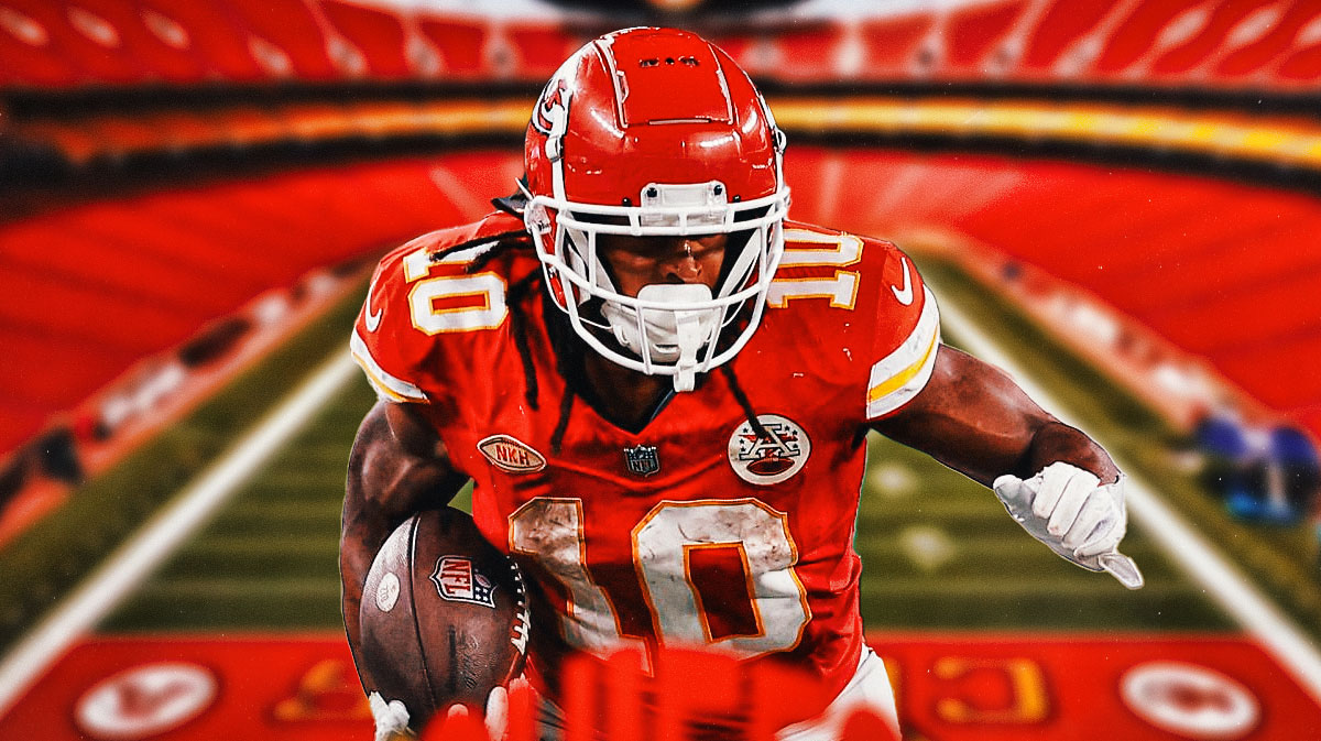 Isiah Pacheco in a Kansas City Chiefs uniform running the ball straight ahead as Pacheco was fined for lowering his head to hit a defender and the NFL fined for unnecessary roughness.