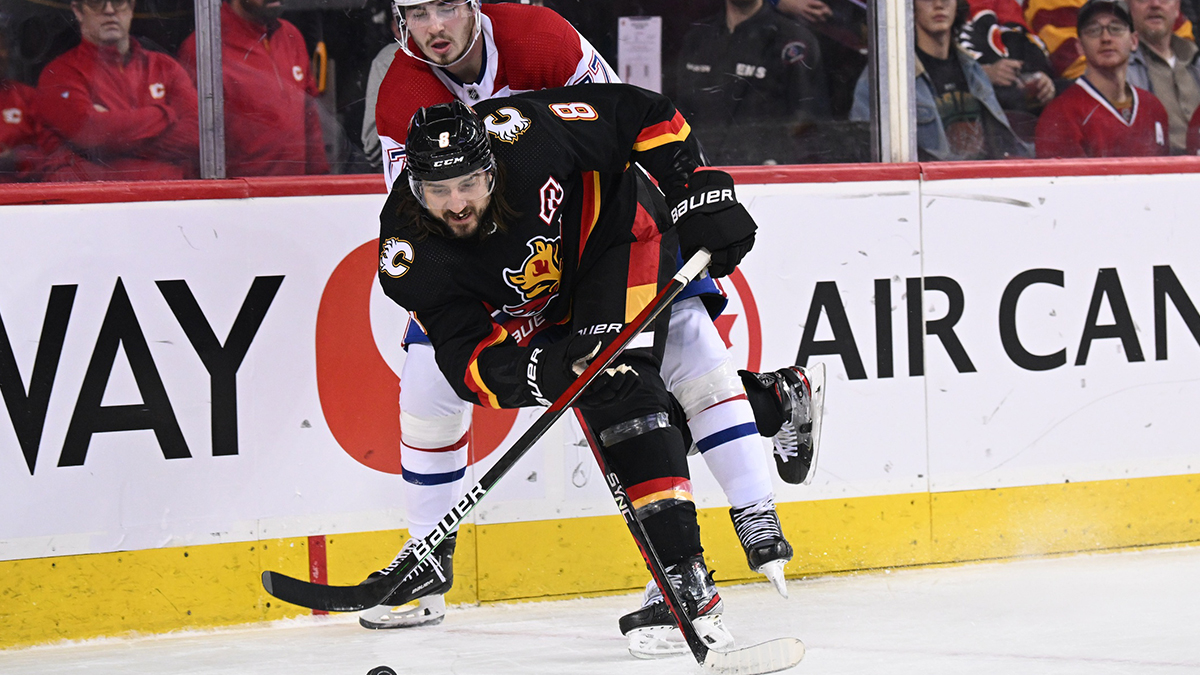 Calgary Flames defenseman Christopher Tanev (8) and Montreal Canadiens forward Kirby Dach (77) battle for the puck in the first period at Scotiabank Saddledome.