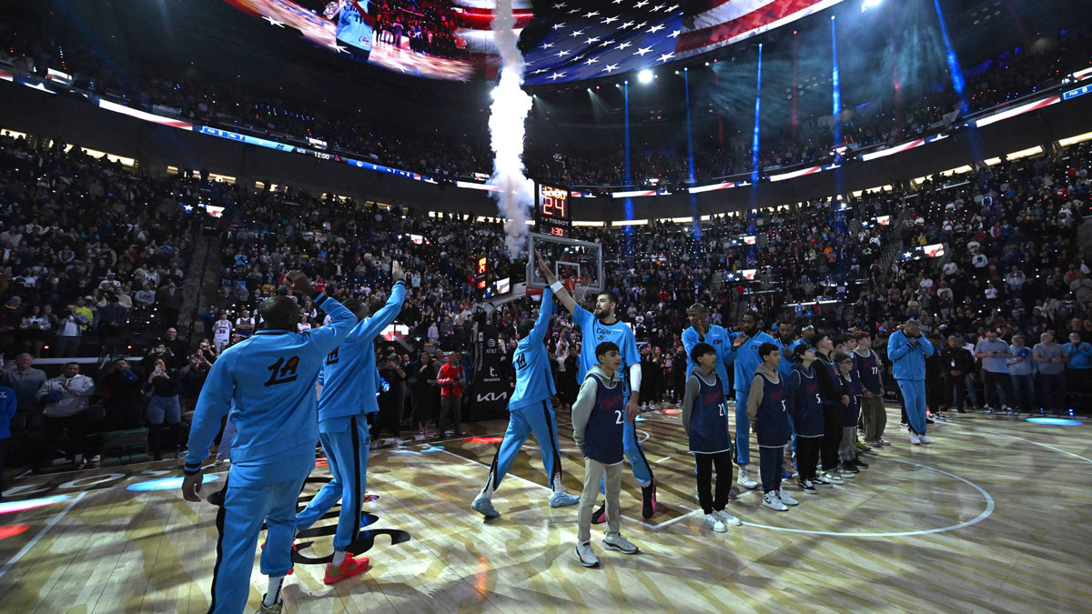 Los Angeles Clippers players high five on the court after team introductions before the game against the Golden State Warriors at Intuit Dome.