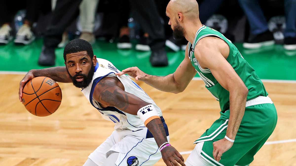 Dallas Mavericks guard Kyrie Irving (11) handles the ball against Boston Celtics guard Derrick White (9) in game five of the 2024 NBA Finals at TD Garden.