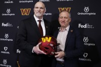 Washington Commanders head coach Dan Quinn (L) poses for a picture with Commanders managing partner Josh Harris (R) at Quinn's introductory press conference at Commanders Park.