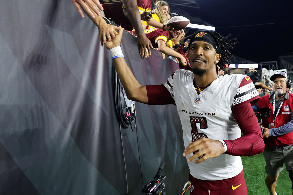 Washington Commanders quarterback Jayden Daniels (5) celebrates with fans following the win against the Cincinnati Bengals at Paycor Stadium.