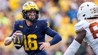 Michigan quarterback Davis Warren (16) looks to makes a pass against Texas linebacker Barryn Sorrell (88) during the second half at Michigan Stadium