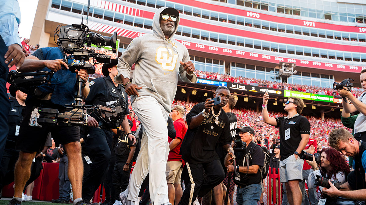 Colorado Buffaloes head coach Deion Sanders runs onto the field before the game against the Nebraska Cornhuskers at Memorial Stadium.