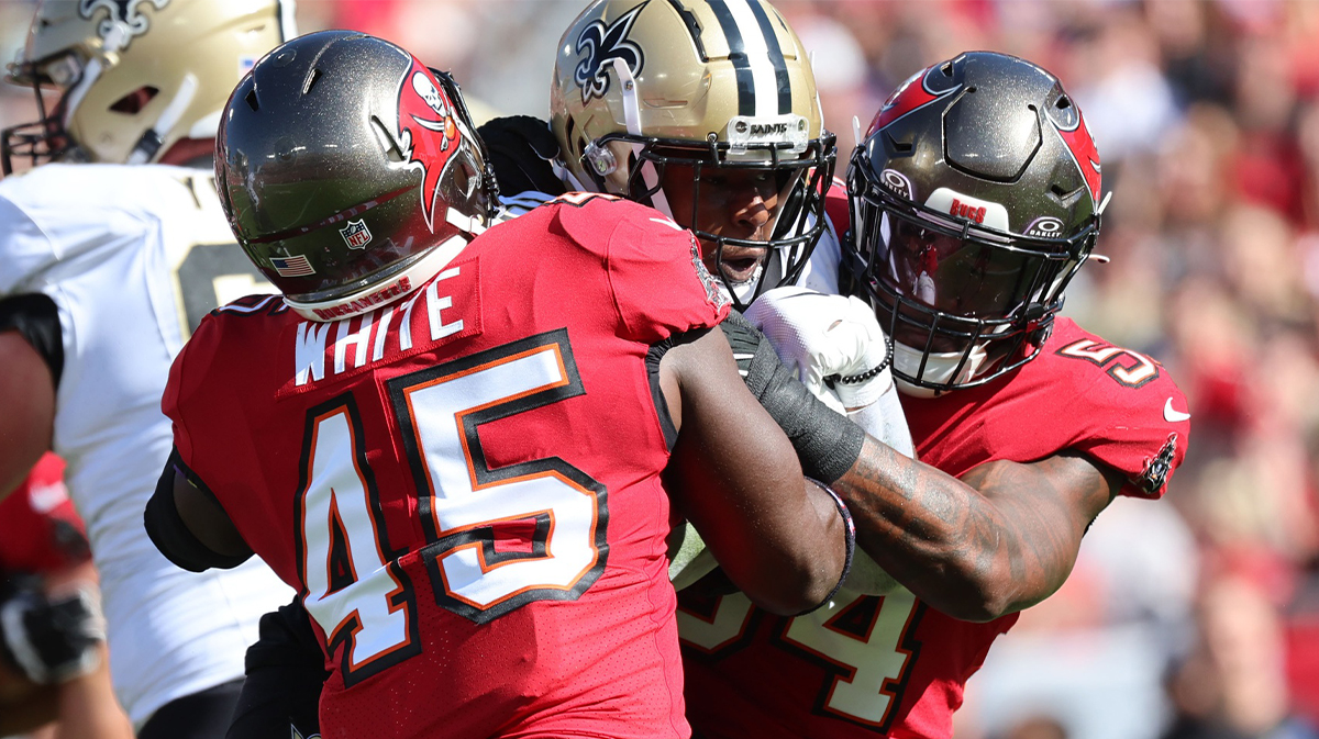 New Orleans Saints running back Jamaal Williams (21) runs with the ball as Tampa Bay Buccaneers linebacker Devin White (45) and linebacker Lavonte David (54) tackle during the first quarter at Raymond James Stadium.