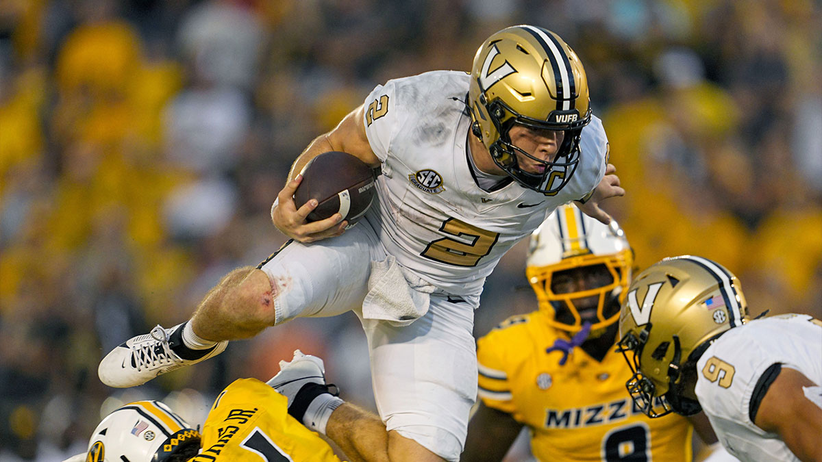 Vanderbilt Commodores quarterback Diego Pavia (2) leaps over Missouri Tigers safety Marvin Burks Jr. (1) during overtime at Faurot Field at Memorial Stadium.