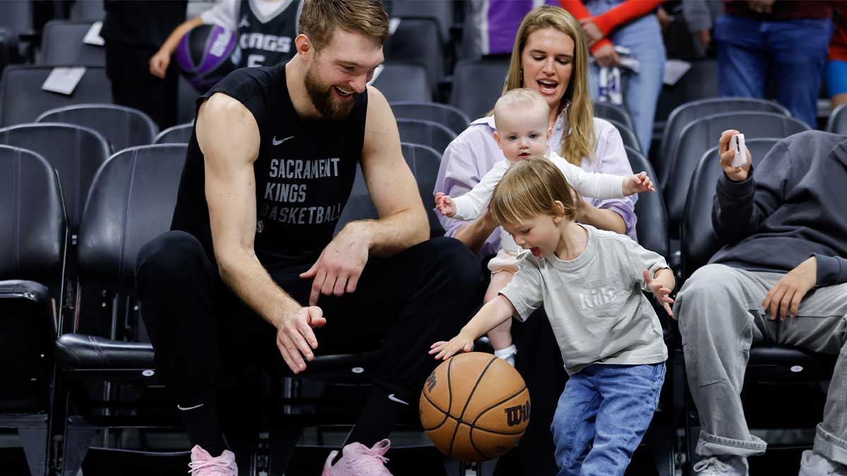 Sacramento Kings forward Domantas Sabonis (10) and his son Oliver Tiger dribble a basketball before a game against the New Orleans Pelicans at Golden 1 Center.