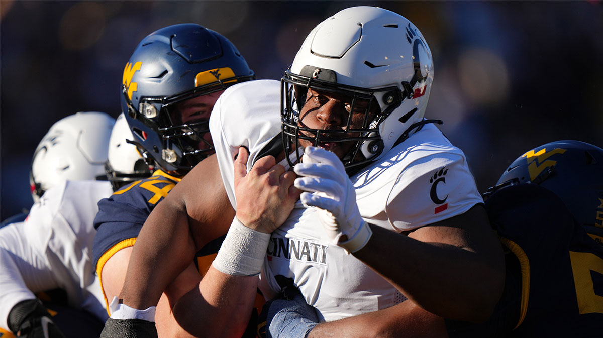 Cincinnati Bearcats defensive lineman Dontay Corleone (2) is double-teamed on a pass rush in the first quarter during an NCAA college football game between the Cincinnati Bearcats and the West Virginia Mountaineers, Saturday, Nov. 18, 2023, at Milan Puskar Stadium in Morgantown, W. Va.