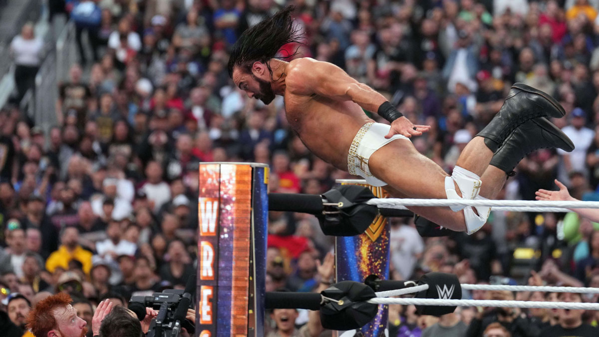 Drew McIntyre jumping over the top rope onto Gunther and Sheamus at WrestleMania 39.
