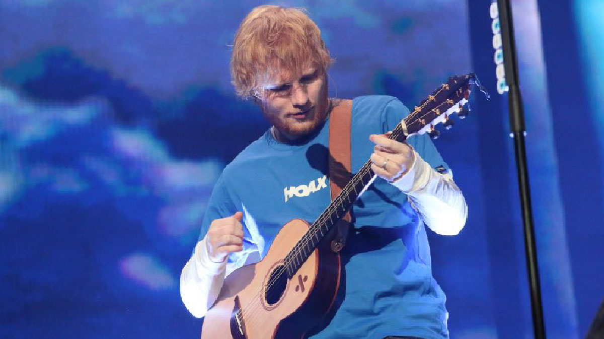 Ed Sheeran playing guitar in 2018 on the Divide Tour.