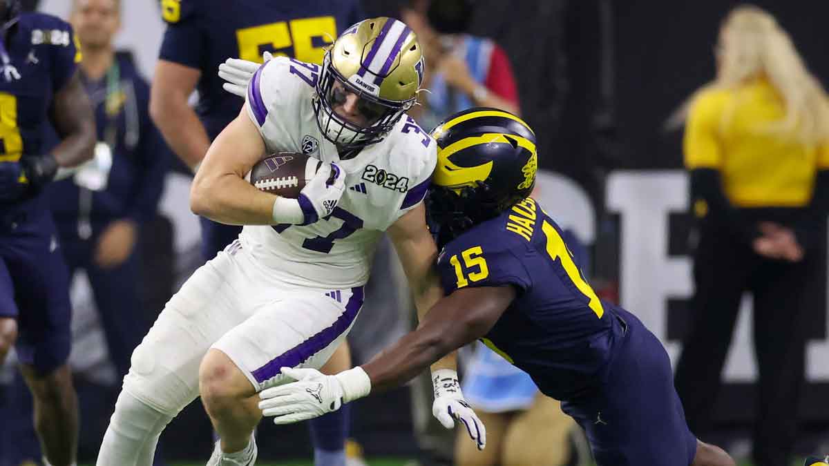 Washington Huskies tight end Jack Westover (37) is tackled by Michigan Wolverines linebacker Ernest Hausmann (15) in the 2024 College Football Playoff national championship game at NRG Stadium. 