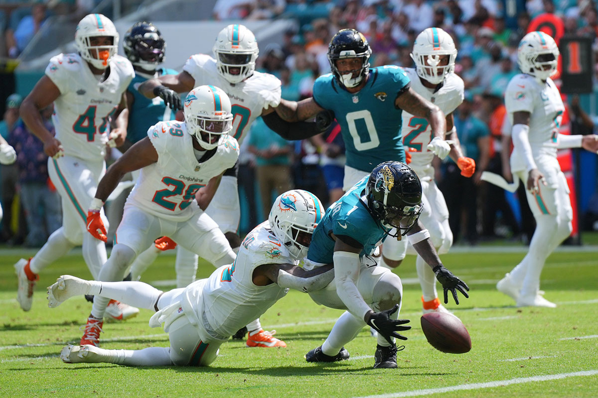Miami Dolphins safety Jevon Holland (8) punches the ball away from Jacksonville Jaguars running back Travis Etienne Jr. (1) causing a fumble that was recovered by the Dolphins in the end zone during the third quarter at Hard Rock Stadium.