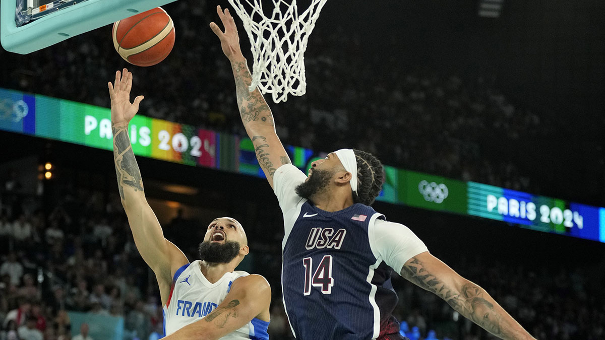 France guard Evan Fournier (10) shoots against United States center Anthony Davis (14) in the second half of the men's basketball gold medal match at the Paris 2024 Summer Olympic Games at Accor Arena.