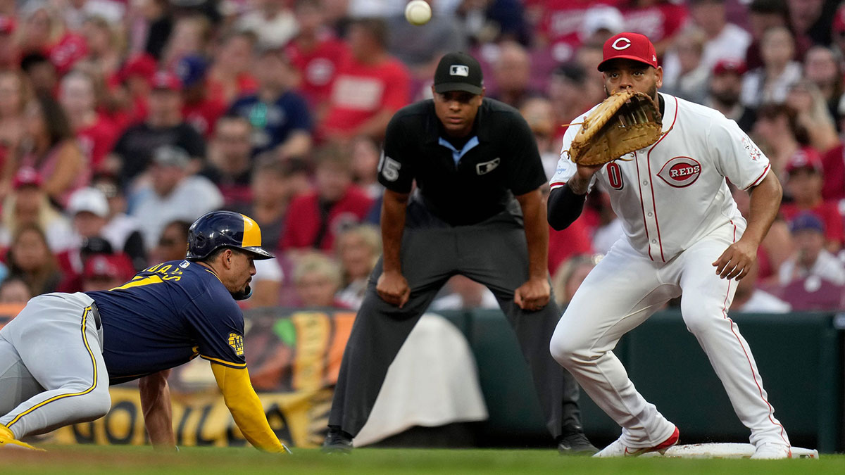 Milwaukee Brewers shortstop Willy Adames (27) slides back to 1st base safely as Cincinnati Reds first baseman Dominic Smith (0) waits for the catch in the 1st inning at Great American Ball Park, Saturday, August 31, 2024.