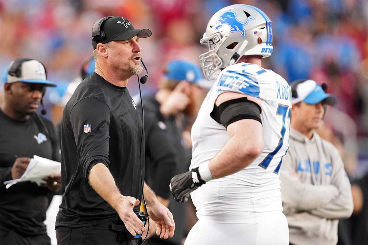 Detroit Lions head coach Dan Campbell high fives center Frank Ragnow (77) after a play against the San Francisco 49ers during the first half of the NFC Championship football game at Levi's Stadium.