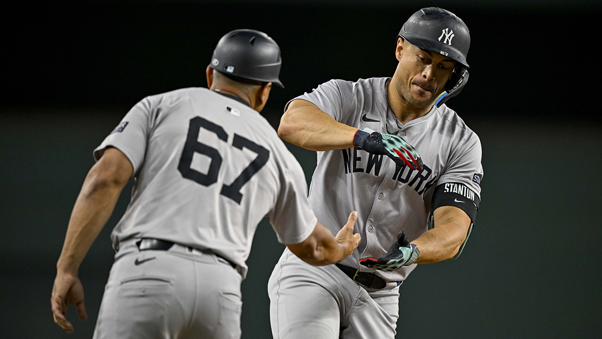 Sep 2, 2024; Arlington, Texas, USA; New York Yankees third base coach Luis Rojas (67) and designated hitter Giancarlo Stanton (27) during the game between the Texas Rangers and the New York Yankees at Globe Life Field. Mandatory Credit: Jerome Miron-Imagn Images