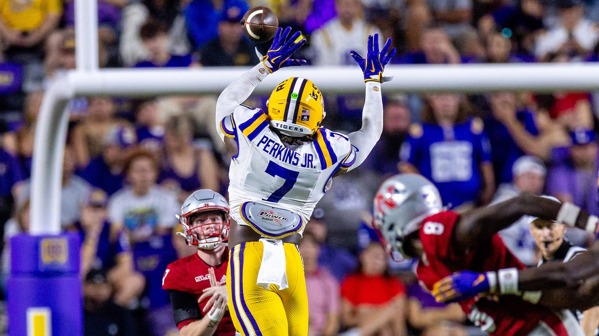 Sep 7, 2024; Baton Rouge, Louisiana, USA; Nicholls State Colonels quarterback Pat McQuaide (7) rolls out of the pocket against LSU Tigers linebacker Harold Perkins Jr. (7) during the second half at Tiger Stadium. Mandatory Credit: Stephen Lew-Imagn Images