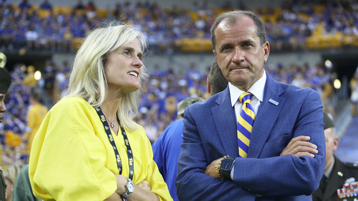 University of Pittsburgh Athletics Director Heather Lyke (left) and ACC Commissioner James J. Phillips (right) talk on the field during the first quarter as the Panthers host the Cincinnati Bearcats at Acrisure Stadium.