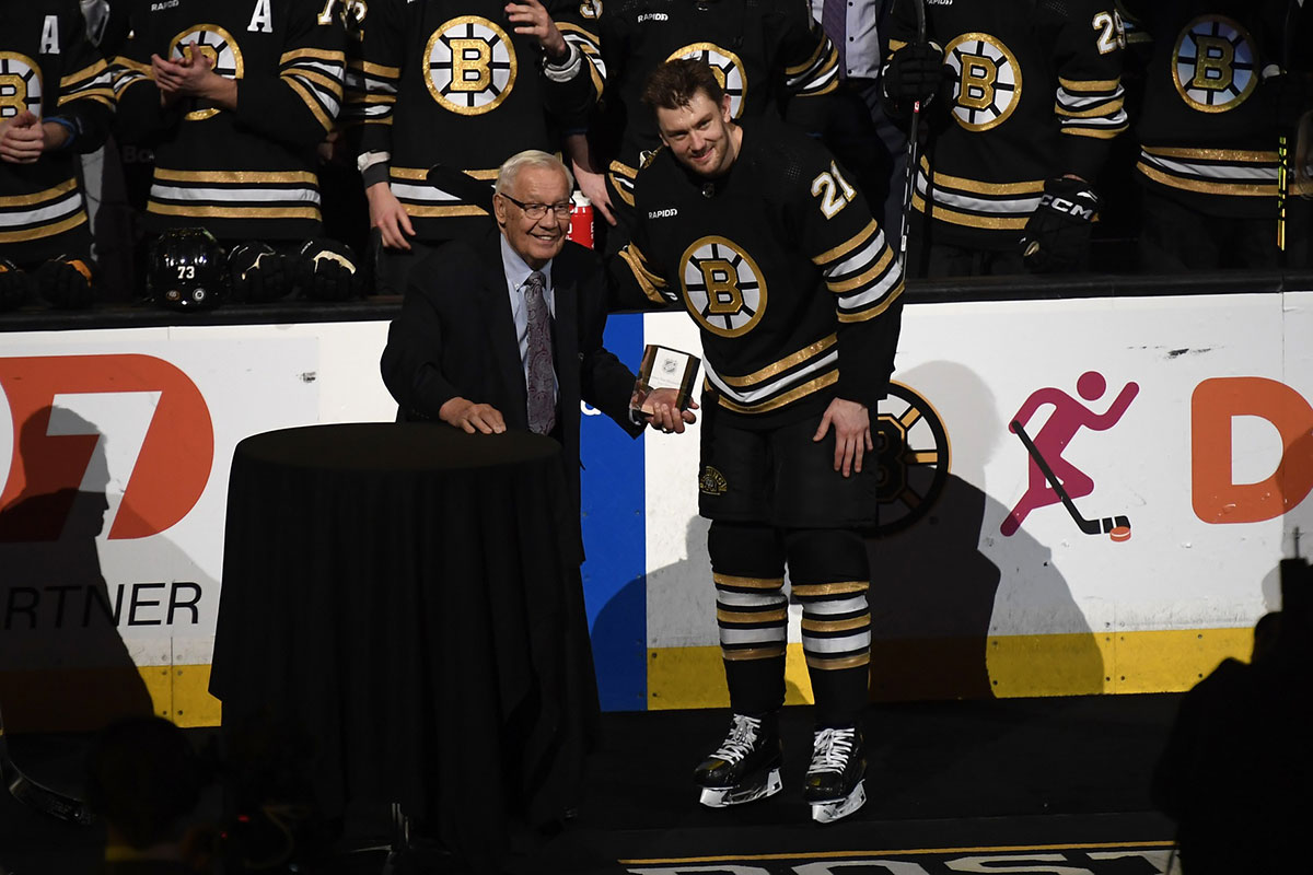 Former Boston Bruins forward Johnny Bucyk presents left wing James van Riemsdyk (21) with an award for playing in his 1000 career game recently prior to a game against the Philadelphia Flyers at TD Garden.