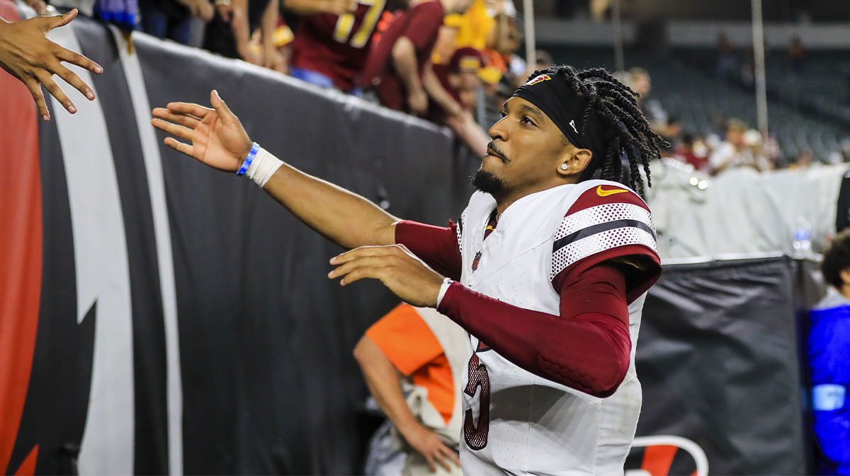 Washington Commanders quarterback Jayden Daniels (5) high fives fans after the victory over the Cincinnati Bengals at Paycor Stadium.