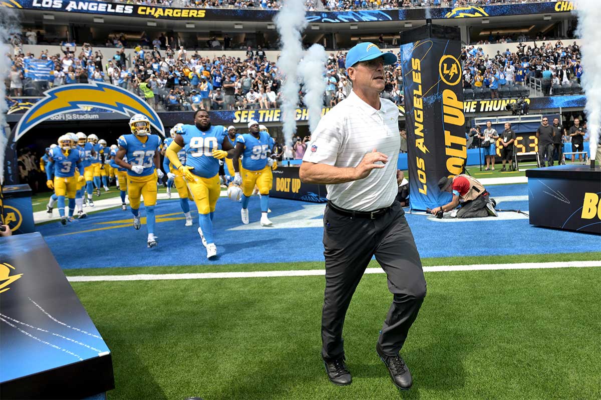 Los Angeles Chargers head coach Jim Harbaugh leads the team on to the field for the game against the Las Vegas Raiders at SoFi Stadium.