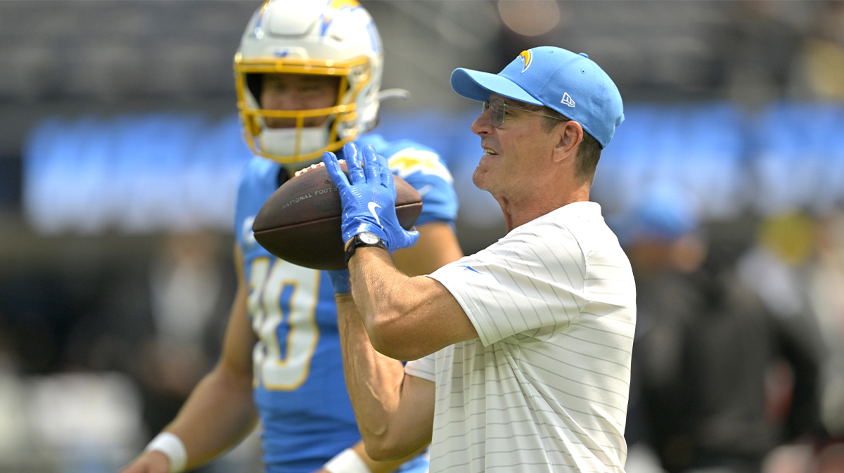 Los Angeles Chargers head coach Jim Harbaugh catches the ball for quarterback Justin Herbert (10) as he warms up prior to the game against the Los Angeles Chargers at SoFi Stadium.