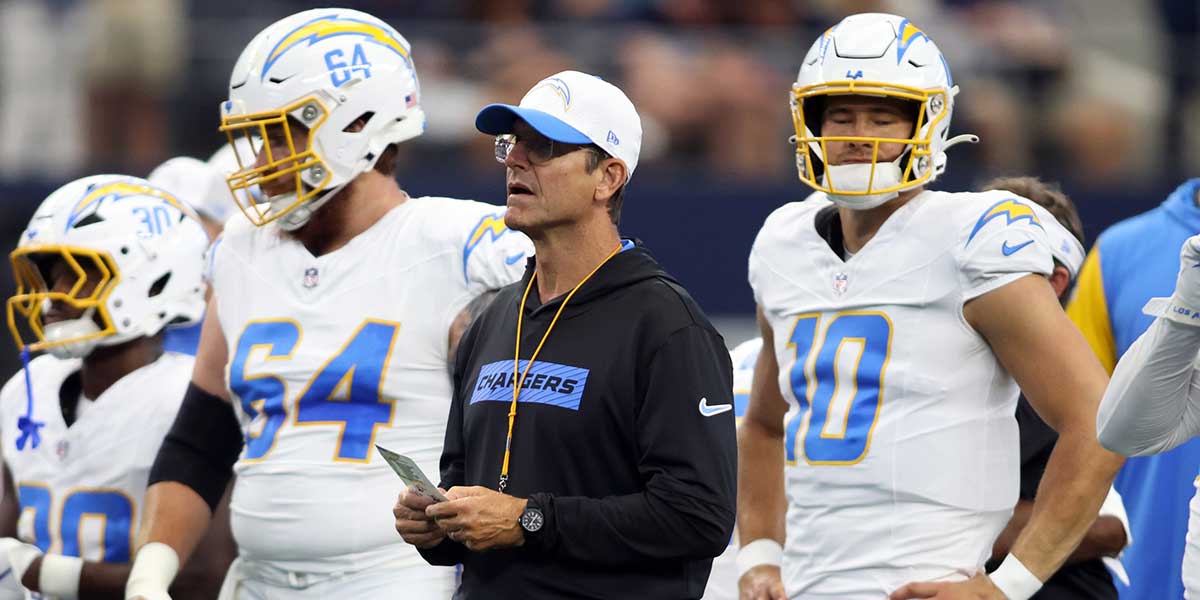 Los Angeles Chargers head coach Jim Harbaugh stands on the field before the game against the Dallas Cowboys at AT&T Stadium.