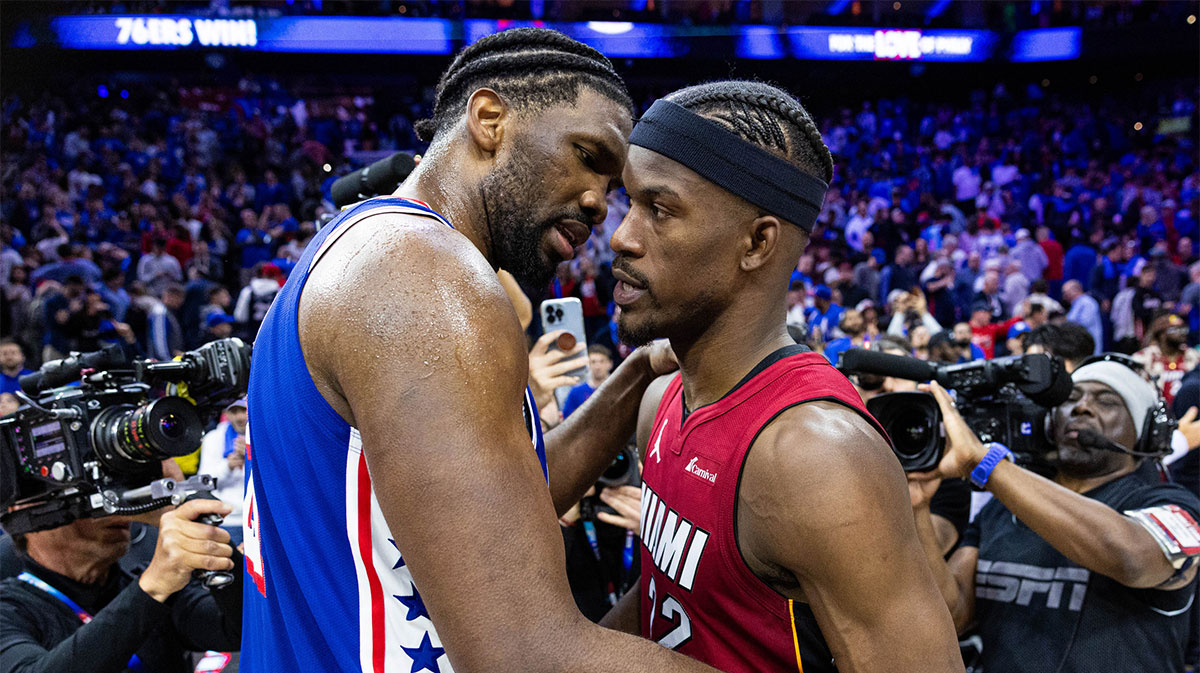 Philadelphia 76ers center Joel Embiid (21) hugs Miami Heat forward Jimmy Butler (22) on the court after a 76ers victory in a play-in game of the 2024 NBA playoffs at Wells Fargo Center.