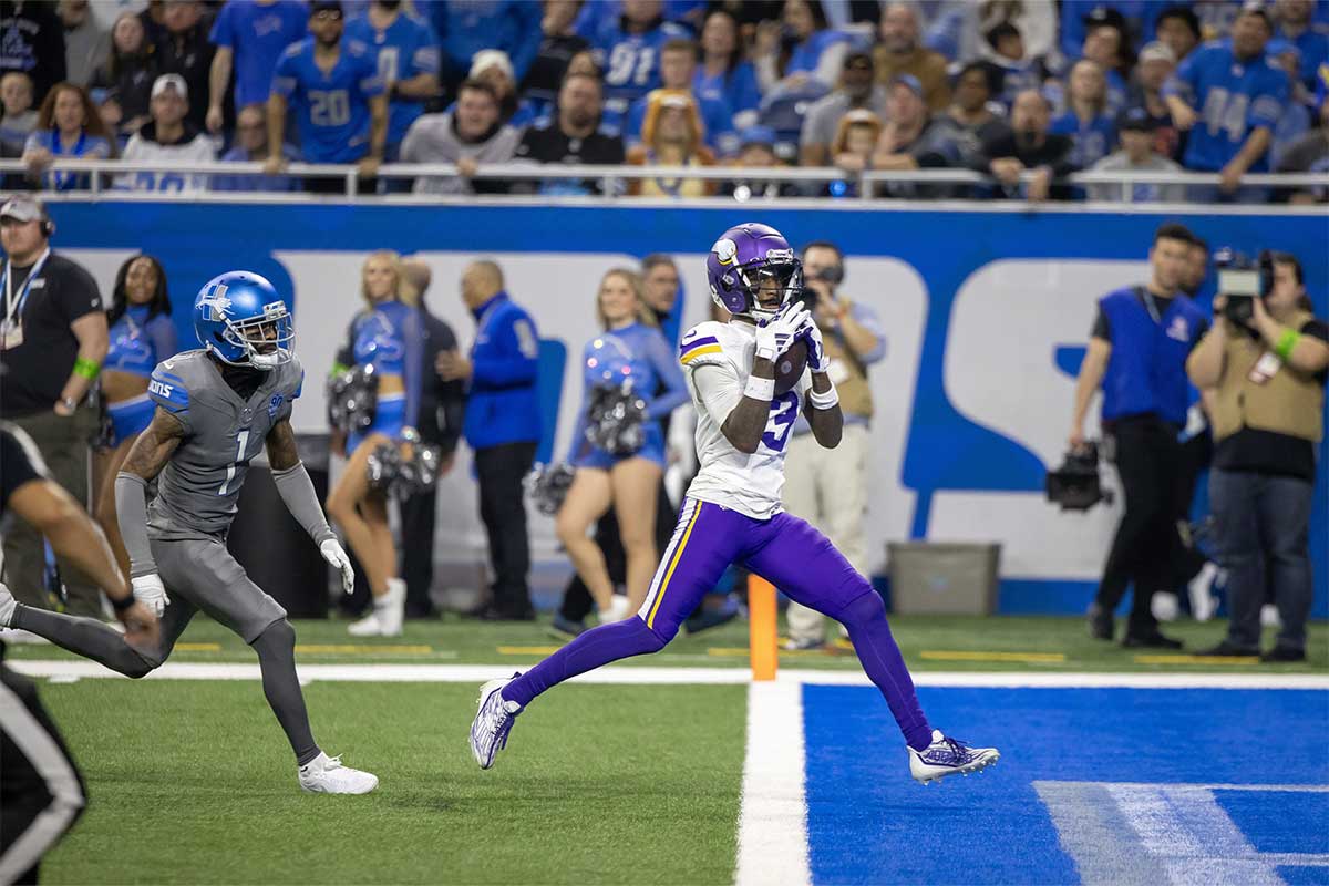 Jan 7, 2024; Detroit, Michigan, USA; Minnesota Vikings wide receiver Jordan Addison (3) catches a pass for a touchdown in front of Detroit Lions cornerback Cameron Sutton (1) during second half at Ford Field.