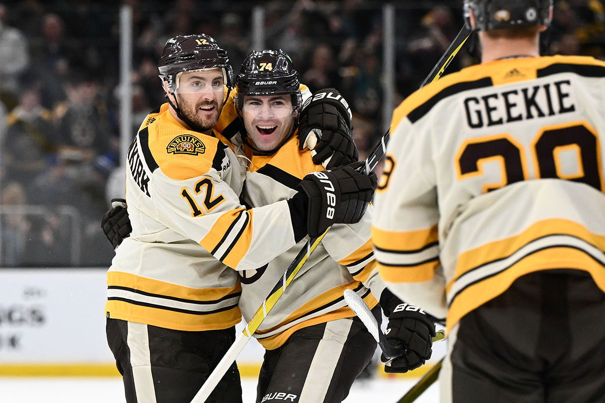 Boston Bruins left wing Jake DeBrusk (74) celebrates with defenseman Kevin Shattenkirk (12) and center Morgan Geekie (39) after scoring a goal against the New York Rangers during the first period at the TD Garden.