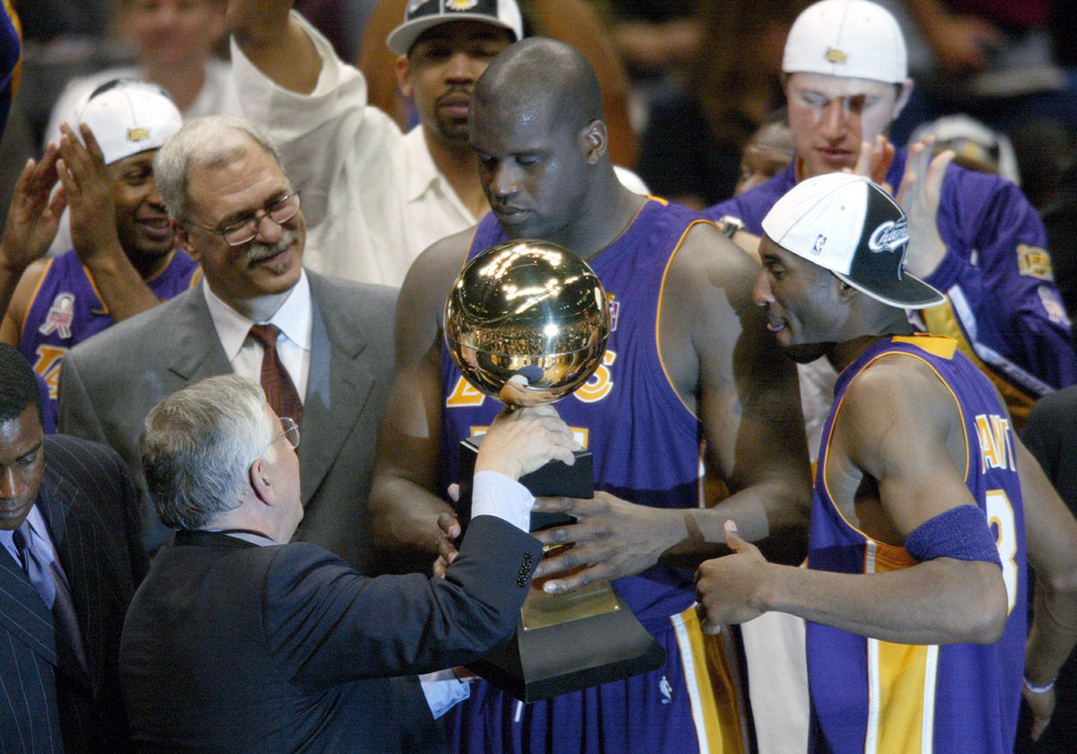 NBA commissioner David Stern hands Los Angeles Lakers Phil Jackson (left), Shaquille O'Neal (center) and Kobe Bryant (right) their championship trophy at the end of Game 4 of the NBA Finals at The Meadowlands.