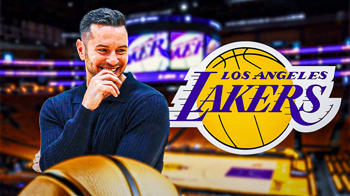 Lakers head coach JJ Redick smiling next to the Lakers logo outside of Crypto.com Arena