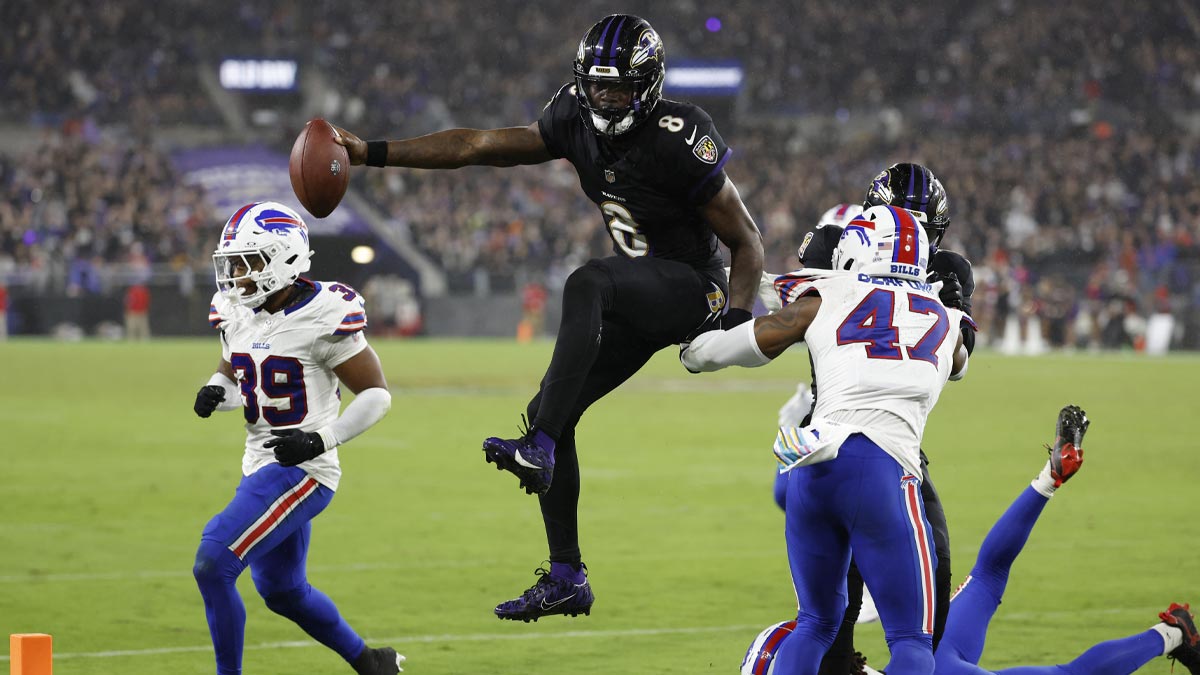 Baltimore Ravens quarterback Lamar Jackson (8) scores a touchdown as Buffalo Bills safety Damar Hamlin (3) and Bills cornerback Christian Benford (47) defend during the third quarter at M&T Bank Stadium.