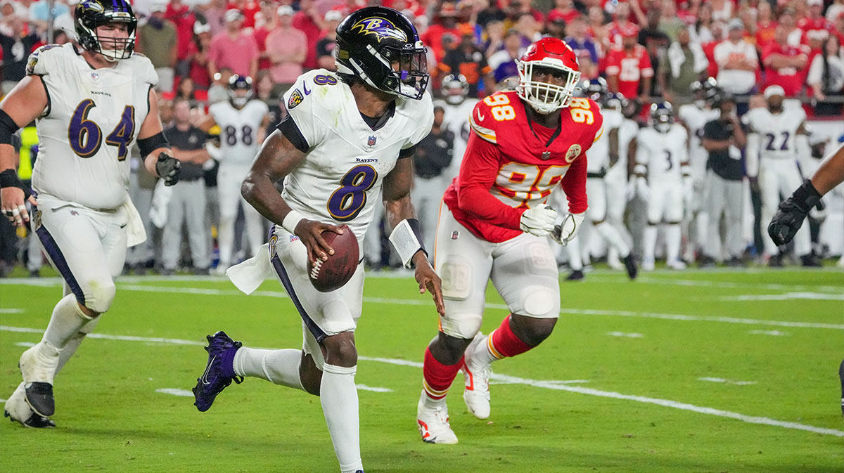 Baltimore Ravens quarterback Lamar Jackson (8) runs the ball as Kansas City Chiefs defensive tackle Tershawn Wharton (98) chases during the second half at GEHA Field at Arrowhead Stadium.