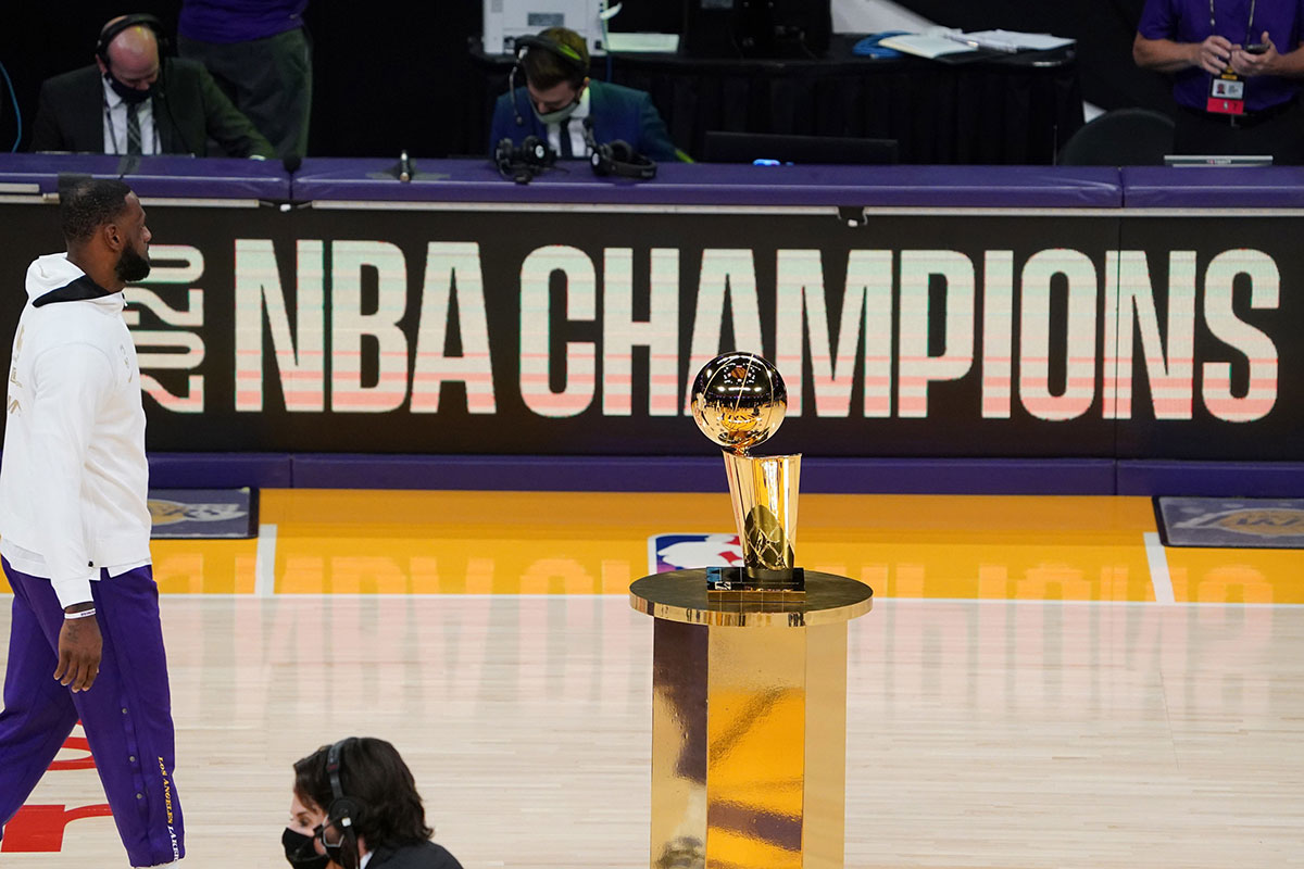 Los Angeles Lakers forward LeBron James (23) walks past the 2020 NBA Championship Larry O'brien trophy before a game between the Lakers and the Los Angeles Clippers at Staples Center.