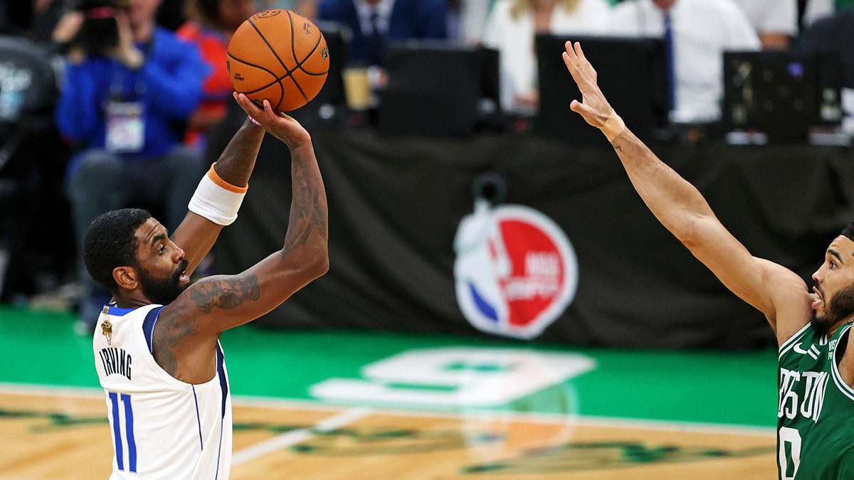 Mavericks guard Kyrie Irving (11) shoots the ball against Boston Celtics forward Jayson Tatum (0) in game five of the 2024 NBA Finals at TD Garden. 