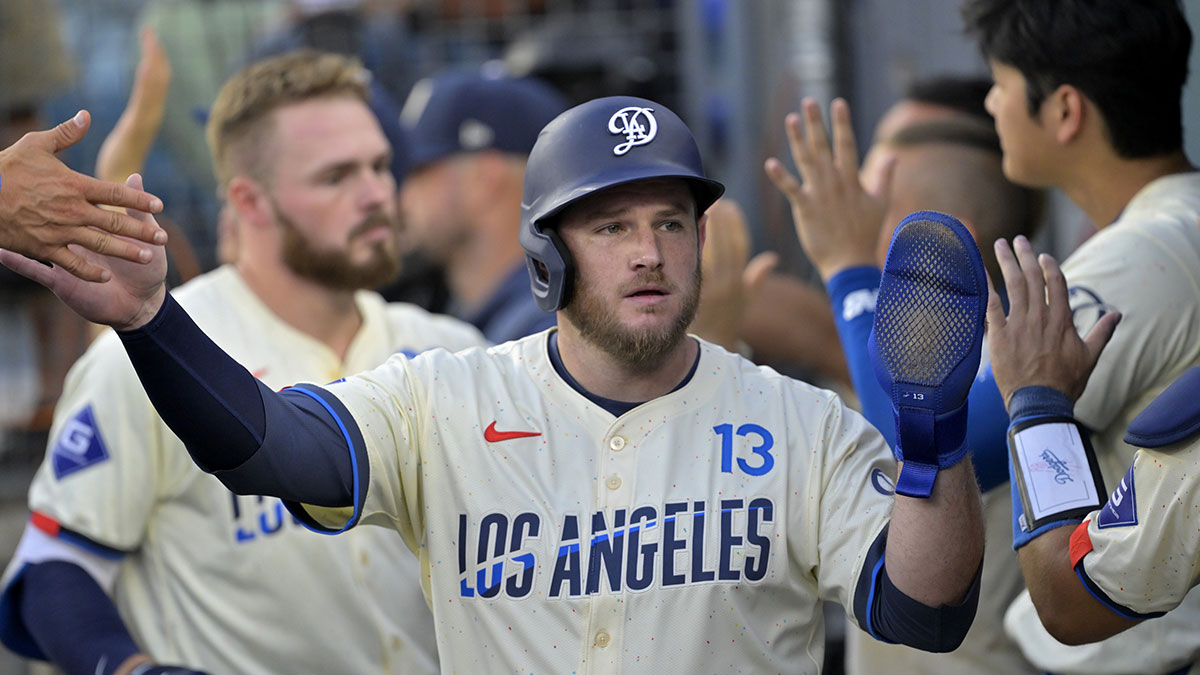 Sep 7, 2024; Los Angeles, California, USA; Los Angeles Dodgers third baseman Max Muncy (13) is greeted in the dugout after scoring on a sacrifice fly by second baseman Gavin Lux (9) in the first inning against the Cleveland Guardians at Dodger Stadium. 