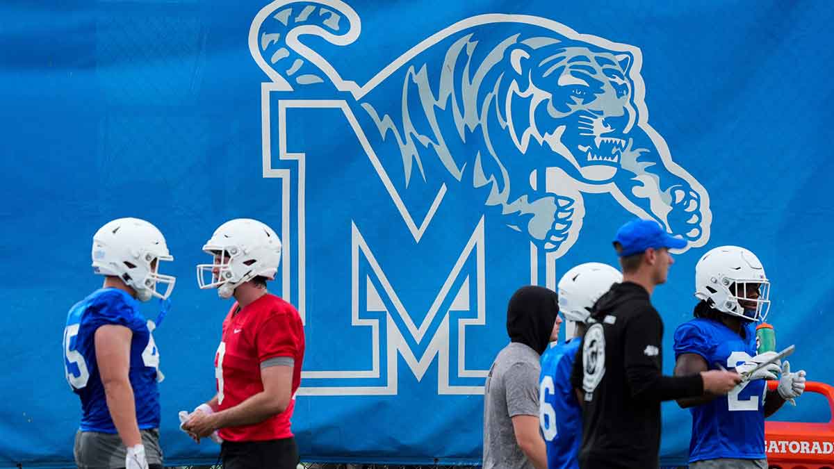 Memphis football players walk by a Memphis logo during practice at the Billy J. Murphy Athletic Complex at the University of Memphis