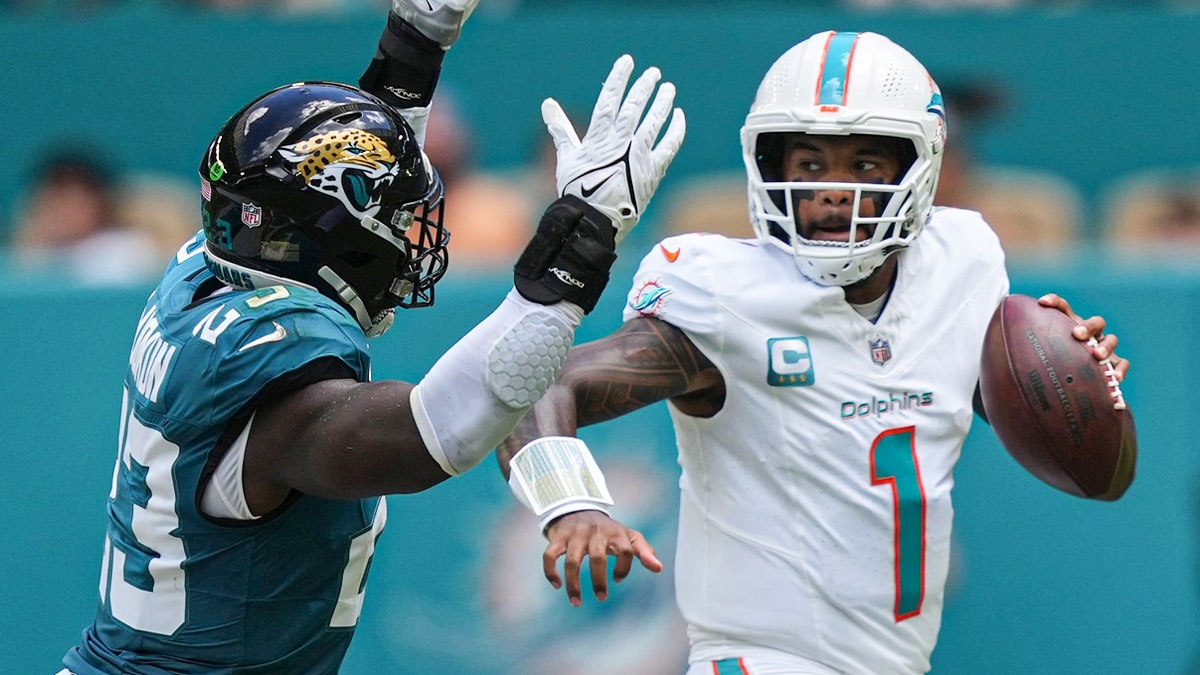 Miami Dolphins quarterback Tua Tagovailoa (1) rolls out to pass as linebacker Foyesade Oluokun (23) follows on the play at Hard Rock Stadium.