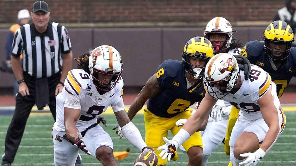 Minnesota wide receiver Daniel Jackson and linebacker Matt Kingsbury converge on the football during a onside kick that got called back because of a flag late in the fourth quarter between Michigan and Minnesota at Michigan Stadium