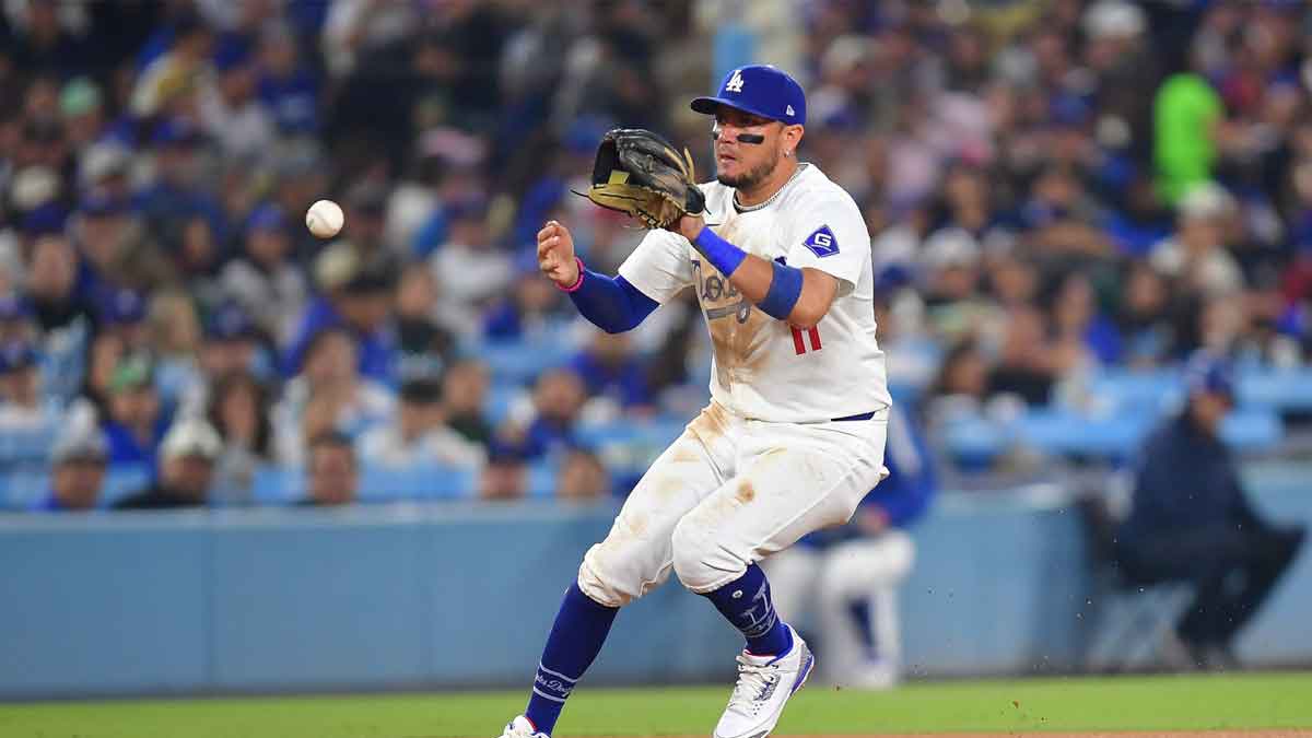 Los Angeles Dodgers third baseman Max Muncy (13) is greeted in the dugout after scoring on a sacrifice fly by second baseman Gavin Lux (9) in the first inning against the Cleveland Guardians at Dodger Stadium. 