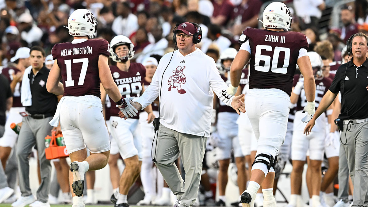 Texas A&M Aggies head coach Mike Elko high fives players as they exit the field during the second quarter against the Notre Dame Fighting Irish at Kyle Field