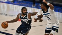 Dallas Mavericks guard Kyrie Irving (11) dribbles against Minnesota Timberwolves center Naz Reid (11) during the second quarter of game four of the western conference finals for the 2024 NBA playoffs at American Airlines Center.