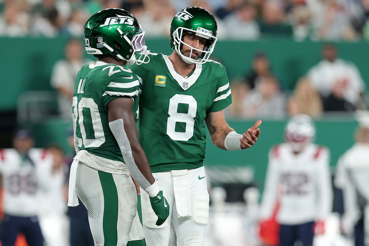 New York Jets quarterback Aaron Rodgers (8) reacts as he talks to running back Breece Hall (20) during the third quarter against the New England Patriots at MetLife Stadium.